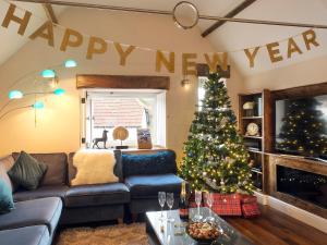 a living room with a christmas tree and a couch at Stone Barn - Ukc3594 in Minehead