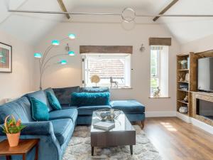 a living room with a blue couch and a table at Stone Barn - Ukc3594 in Minehead