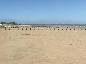 a beach with a row of posts in the sand at Yew Tree House Cottage in New Romney
