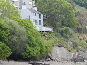 a house on the side of a hill next to a river at Tan Y Fford in Bangor