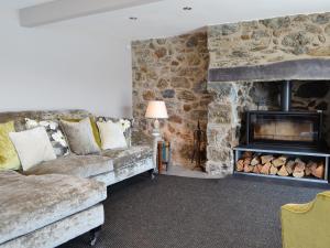a living room with a couch and a fireplace at Tan Y Fford in Bangor
