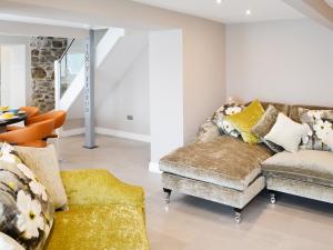 a living room with a couch and a chair at Tan Y Fford in Bangor