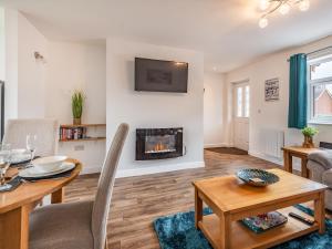a living room with a table and a fireplace at Sycamore Lodge - Uk35106 in Chapel Saint Leonards