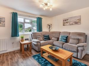 a living room with a couch and a table at Sycamore Lodge - Uk35106 in Chapel Saint Leonards