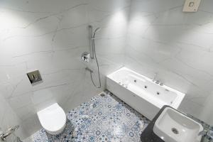 a bathroom with a tub and a toilet and a sink at Hotel Bobina in Gorakhpur