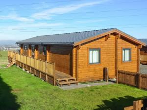 a log cabin with a porch and a deck at Coo Lodge - Uk48430 in Falkirk