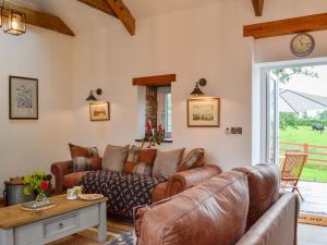 a living room with a couch and a table at Sgubor Llwyndu in Bettws