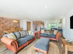 a living room with two couches and a brick wall at Dragonfly Den - Uk44530 in Horncastle