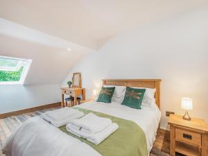 a bedroom with a large bed with towels on it at Dragonfly Den - Uk44530 in Horncastle