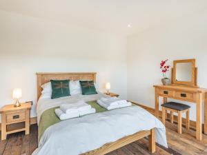 a bedroom with a bed with a mirror and a chair at Dragonfly Den - Uk44530 in Horncastle
