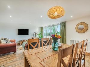 a living room with a dining room table with a vase of flowers at Dragonfly Den - Uk44530 in Horncastle +15 photos