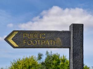 a sign that says public footpath on a pole at The Granary Store in Woodrising