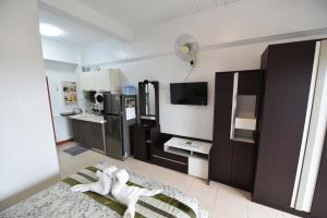 a living room with a kitchen with a refrigerator at Rayong Condochain 325 in Ban Pak Khlong Phe