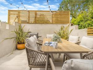 a patio with a wooden table and chairs at Ty Mor in Abersoch