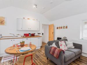 a living room with a couch and a table at Ty Macsen in Llanwnda