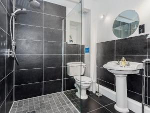 a bathroom with a toilet and a sink and a shower at Ty Macsen in Llanwnda +5 photos