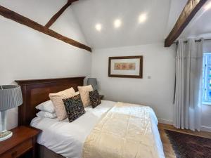 a bedroom with a bed with white sheets and pillows at Eagles Nest in Guildford
