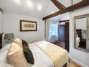 a bedroom with a white bed and a mirror at Eagles Nest in Guildford