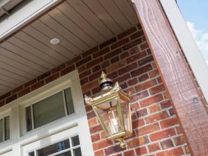 a lantern hanging on the side of a brick house at The Pavilion in Willoughby