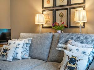 a living room with a couch with pillows and two lamps at The Pavilion in Willoughby