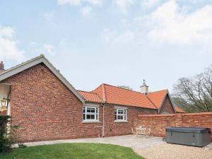 a brick house with a table and a fence at The Pavilion in Willoughby
