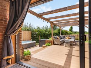 a wooden deck with a pergola and a couch at Lucky's Stable - Uk34101 in Chichester