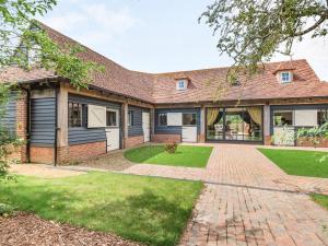 an exterior view of a house with a brick driveway at Lucky's Stable - Uk34101 in Chichester
