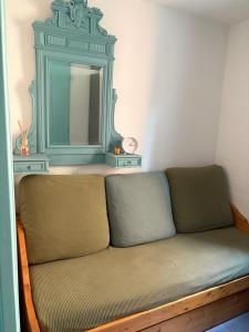 a couch with a mirror in a room at Maisonnette les oliviers in Argelès-sur-Mer