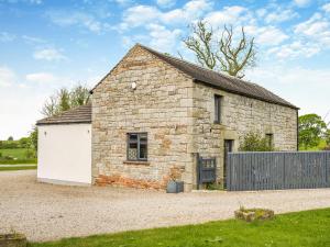an old stone barn with a white garage at Whitehill Barn - Uk47195 in Kirkcambeck