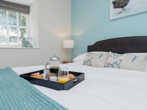 a tray with food and drinks on a bed at The Barn At Grislow Field in Curbar