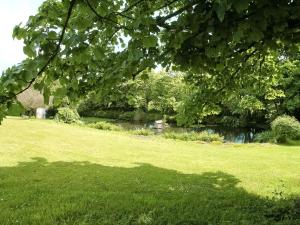 a park with a river and trees and a grass field at The Barn in Carleen