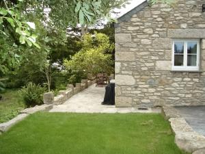 a stone house with a lawn and a window at The Barn in Carleen