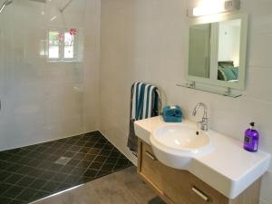 a white bathroom with a sink and a shower at The Barn in Carleen +3 photos