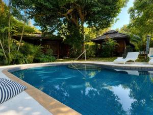 a swimming pool with two chairs and a house at Hidden Home Samui in Koh Samui