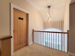 a hallway with a wooden door in a house at The Birches - Ukc4619 in Dunholme