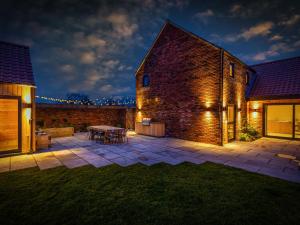 a patio with a table and a brick building at The Birches - Ukc4619 in Dunholme +4 photos