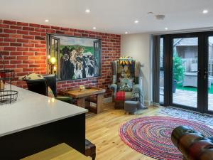 a living room with a brick wall at Carreg Gwenlais Barn in Carmel