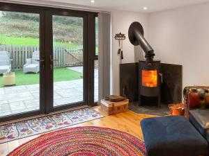 a living room with a wood stove in a living room at Carreg Gwenlais Barn in Carmel