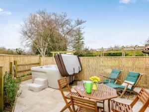 a backyard with a hot tub and a table and chairs at The Hayloft - Ukc1038 in Hickling