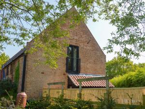 a brick building with a window and a fence at The Hayloft - Ukc1038 in Hickling