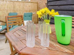 four clear glass vases sitting on a wooden table at The Hayloft - Ukc1038 in Hickling