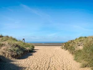 a dirt road leading to the ocean on a beach at Marshall Cottage in Santon