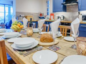 a wooden table with white plates and glasses on it at Ystwyth House in Borth
