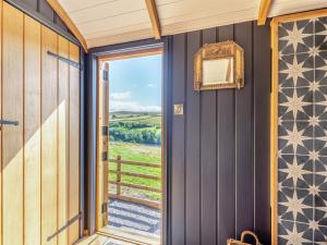 a room with a door leading to a balcony with a view at Flossys Hut - Uk43675 in Haworth
