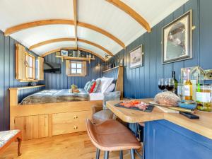 a bedroom with blue walls and a bed with a table at Flossys Hut - Uk43675 in Haworth