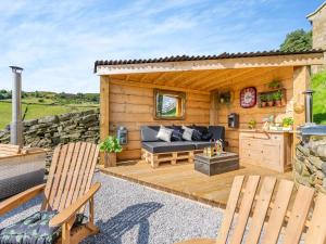 a wooden patio with a couch and two chairs at Flossys Hut - Uk43675 in Haworth +7 photos