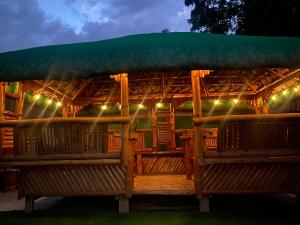 a restaurant with a large umbrella and benches at night at Valdez & Ismail HOMESTAY in Apatot