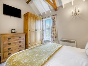 a bedroom with a bed and a dresser and a window at The Hayloft - Uk47153 in Burgh le Marsh