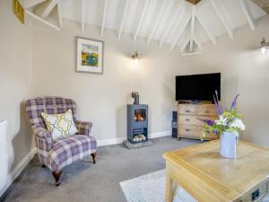a living room with a fireplace and a tv at The Hayloft - Uk47153 in Burgh le Marsh