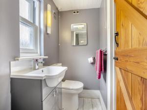 a bathroom with a white sink and a toilet at The Hayloft - Uk47153 in Burgh le Marsh +3 photos